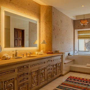 Unwind in this luxurious bathroom featuring a soaking tub, ornate vanity, and warm lighting for your ultimate relaxation.