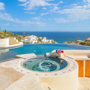 Stunning infinity pool and built-in hot tub overlook the sparkling ocean, creating your own private oasis under endless blue skies.