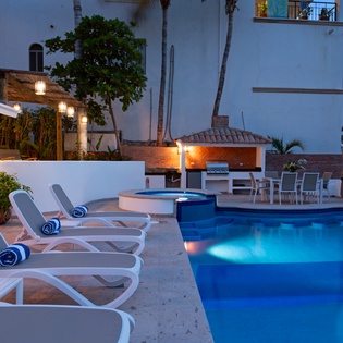 Unwind poolside as evening lights create perfect ambiance for your tropical escape with dining and relaxation.