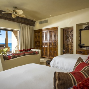 Wake up to stunning ocean views from your luxurious beachfront bedroom, where handcrafted furnishings and plush linens create your perfect seaside sanctuary.