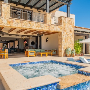 Luxurious stone villa with bubbling hot tub, pool, and covered terrace perfect for outdoor entertaining.