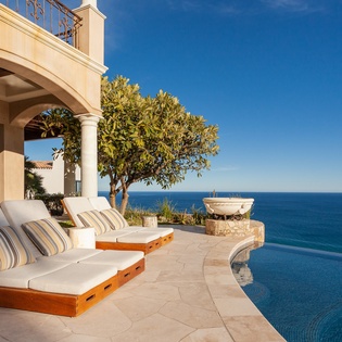 Lounge chairs by poolside with ocean views