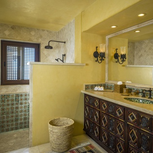 Unwind in your luxurious Moroccan-inspired bathroom featuring hand-painted tiles, a rainfall shower, and authentic artisan details that transport you to an exotic sanctuary.