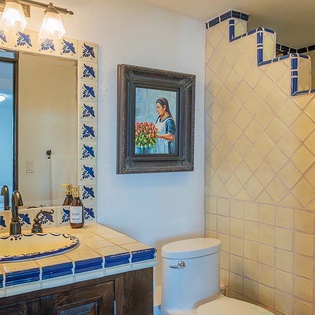 Step into your ensuite bathroom adorned with handcrafted Mexican tiles and charming artistic touches. The spacious walk-in shower and thoughtful details create a soothing retreat after your day.