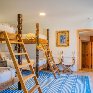 Your unique bunk room features handcrafted wooden beds with intricate carved posts, creating an adventurous yet cozy retreat for memorable nights.