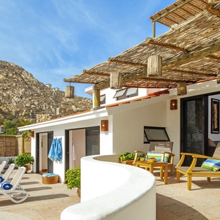 Relax on your private terrace with comfortable lounge chairs and mountain views, perfect for unwinding under the pergola's shade.
