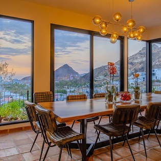 Mountain views frame a stylish dining space with warm lighting, perfect for memorable meals with friends and family.