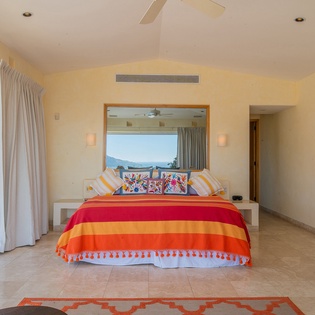 Drift to sleep in your vibrant bedroom sanctuary, where tropical mountain views and colorful Mexican textiles create pure relaxation.