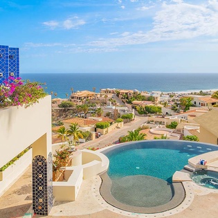 A stunning coastal oasis awaits you—this private pool and hot tub sit framed by lush bougainvillea and sweeping ocean views, offering the perfect setting for your sun-soaked escape.