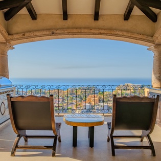 Sip your morning coffee at this elegant covered terrace, where stone arches frame breathtaking sea views and mountain vistas beyond.