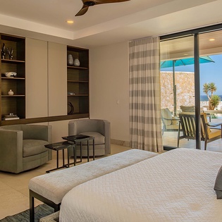 Picture yourself waking in this serene bedroom, where your private terrace opens to sparkling ocean views. Relax in the sitting area, then step outside to bask in coastal breezes and endless blue horizons.
