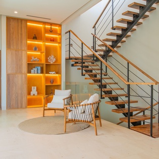 Relax in your modern living space with stunning warm wood accents and dramatic floating staircase creating architectural elegance.