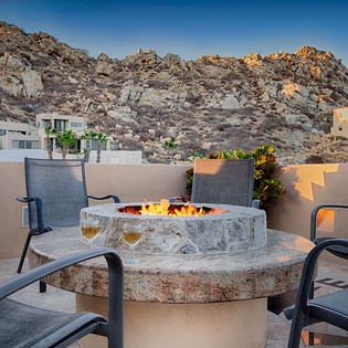 A dramatic desert mountain backdrop frames the rooftop terrace, where you'll find a custom stone fire pit perfect for cool desert evenings with wine and stargazing.