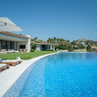 Poolside patio with lounge chairs and ocean views