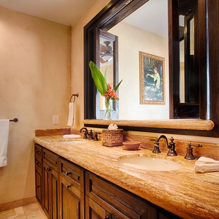 Freshen up in your spacious bathroom featuring elegant dual vanities, warm natural tones, and plush towels—a serene retreat for your morning and evening routines.