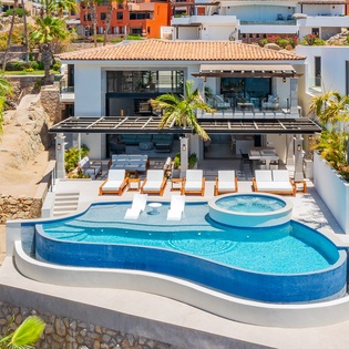 Modern villa nestled in a vibrant hillside community, featuring contemporary architecture and tropical surroundings.