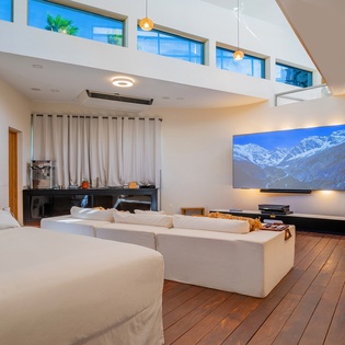 Unwind in your sophisticated living space with soaring ceilings, plush seating, and stunning mountain views on the big screen.