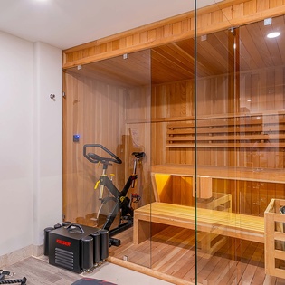 Unwind in your private sauna with heated volcanic stones after a workout, enjoying the warm cedar embrace and gentle glow—a spa-like retreat just steps from your door.