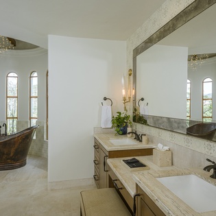 Indulge in luxury with your private spa-like bathroom featuring a dramatic copper soaking tub and elegant dual vanities.
