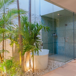 Tropical en suite bathroom with bathtub and walk in shower