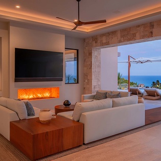 Sink into plush seating and soak in stunning ocean views stretching beyond your private infinity pool. Warm evenings glow with ambient fireplace light as you unwind in effortless luxury.