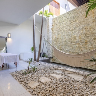 Unwind in your private tropical sanctuary with a luxurious hammock overlooking a zen garden complete with natural stone pathways.