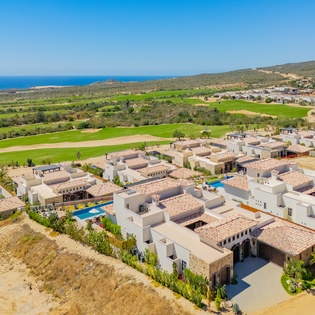 Mediterranean-style resort community set against championship golf course, with sparkling pools and coastal views defining this luxury destination.