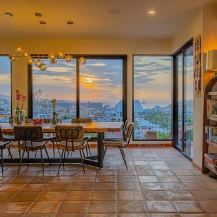 Gather around this sunlit dining table as golden hour paints the sky and mountains beyond the floor-to-ceiling windows—your evenings here will be unforgettable.