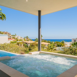 Slip into your private hot tub and soak while gazing at the turquoise sea beyond swaying palms.