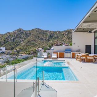 Modern luxury villa featuring a pristine pool and scenic mountain backdrop in an exclusive hillside location.