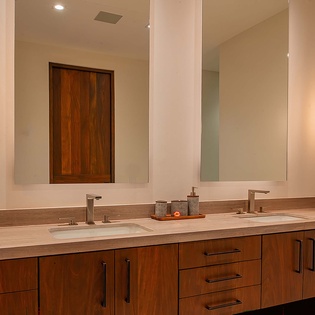 Step into your serene bathroom featuring a spacious double vanity with elegant wood cabinetry and soft lighting that creates a warm, spa-like atmosphere for your morning routine.