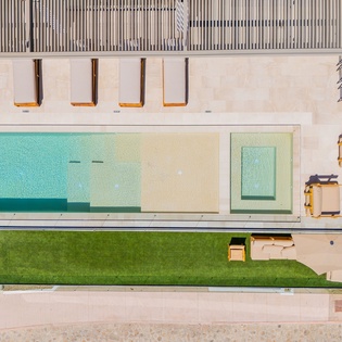 Modern architectural property featuring a stunning swimming pool, manicured lawn, and contemporary design elements captured from above.