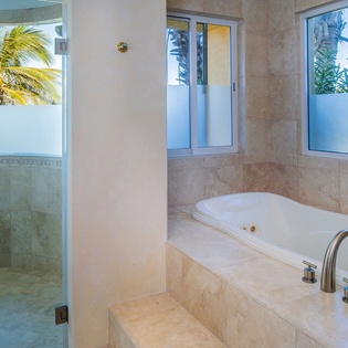 Soak in your luxurious marble tub while gazing at tropical palms and hillside views through floor-to-ceiling windows.