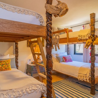 Sleep under hand-carved wooden canopies with intricate details and colorful textiles creating your perfect family retreat.
