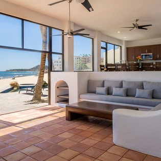 Spacious living area with beachfront views and patio access