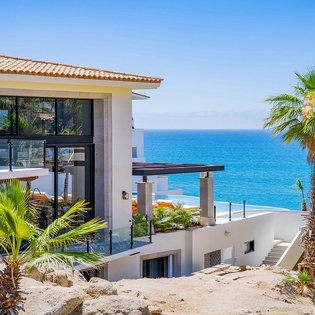 Modern coastal villa with stunning ocean views and tropical landscaping in a serene beachside setting.