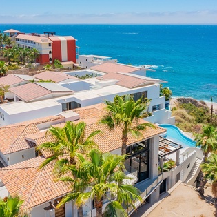 Stunning oceanfront property with pool and tropical gardens, perfectly positioned between azure waters and vibrant coastal community.