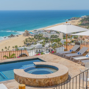 Stunning oceanfront terrace with infinity pool and hot tub overlooking pristine beach and turquoise waters.