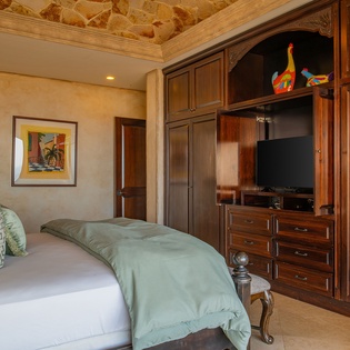 Sink into your luxurious bed surrounded by rich wood cabinetry and stone accents for the perfect retreat.