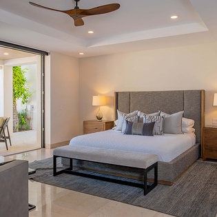 Sink into your plush king bed after a day exploring, with soft lighting and patio doors opening to lush greenery just steps away.