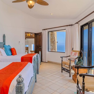 Wake to endless ocean views framed by expansive windows and sliding doors that open your space to the sea breeze. The vibrant decor and charming twin beds promise comfort and coastal charm throughout your stay.