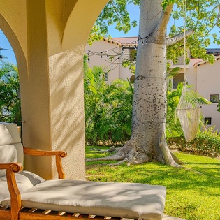 Your private terrace opens onto lush tropical gardens with swaying palms and soft grass, perfect for morning coffee or an afternoon escape.