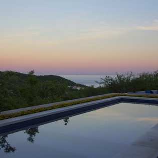 Pool with ocean view during sunset