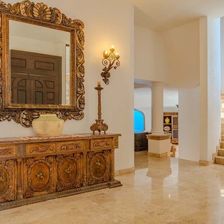 This stunning entry welcomes you with ornate furnishings, glowing sconces, and sun-washed spaces that set the tone for your elegant getaway.