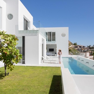 Modern white villa with pristine pool and hillside views offers the perfect Mediterranean escape.