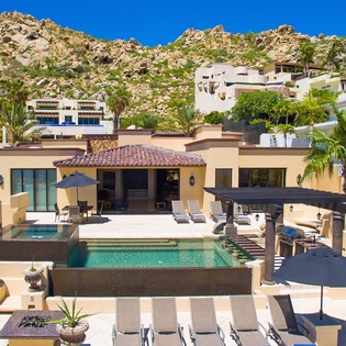This hillside retreat features a private pool, multiple sun decks, and dramatic mountain views. Lush palms and tiered terracing create a serene, resort-style atmosphere for your getaway.