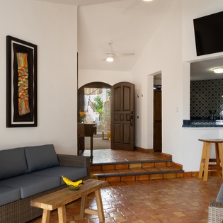 Relax in your stylish living space where vibrant artwork, cozy seating, and an open kitchen create the perfect retreat atmosphere.