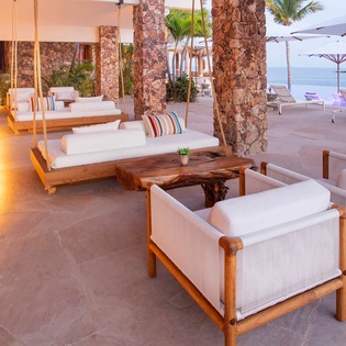 A breathtaking beachfront lounge area where your mornings begin with ocean breezes and gentle waves, perfect for unwinding under swaying palms.
