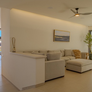 Unwind in your spacious living room where modern comfort meets serene style, with plush seating and calming natural light flowing through expansive windows.