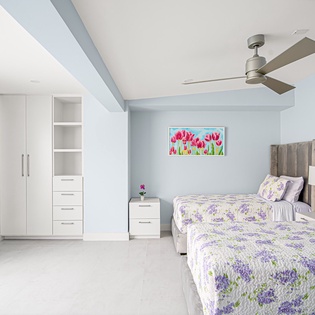 Drift off peacefully in your bright twin bedroom, where floral linens and garden views create a serene sanctuary.